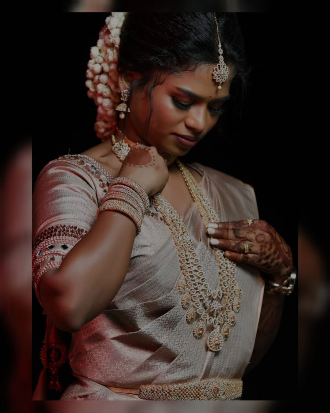 Bridal candid moment adjusting jewellery before makeup shoot